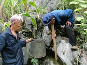 村民利用竹筒收集石洞的水